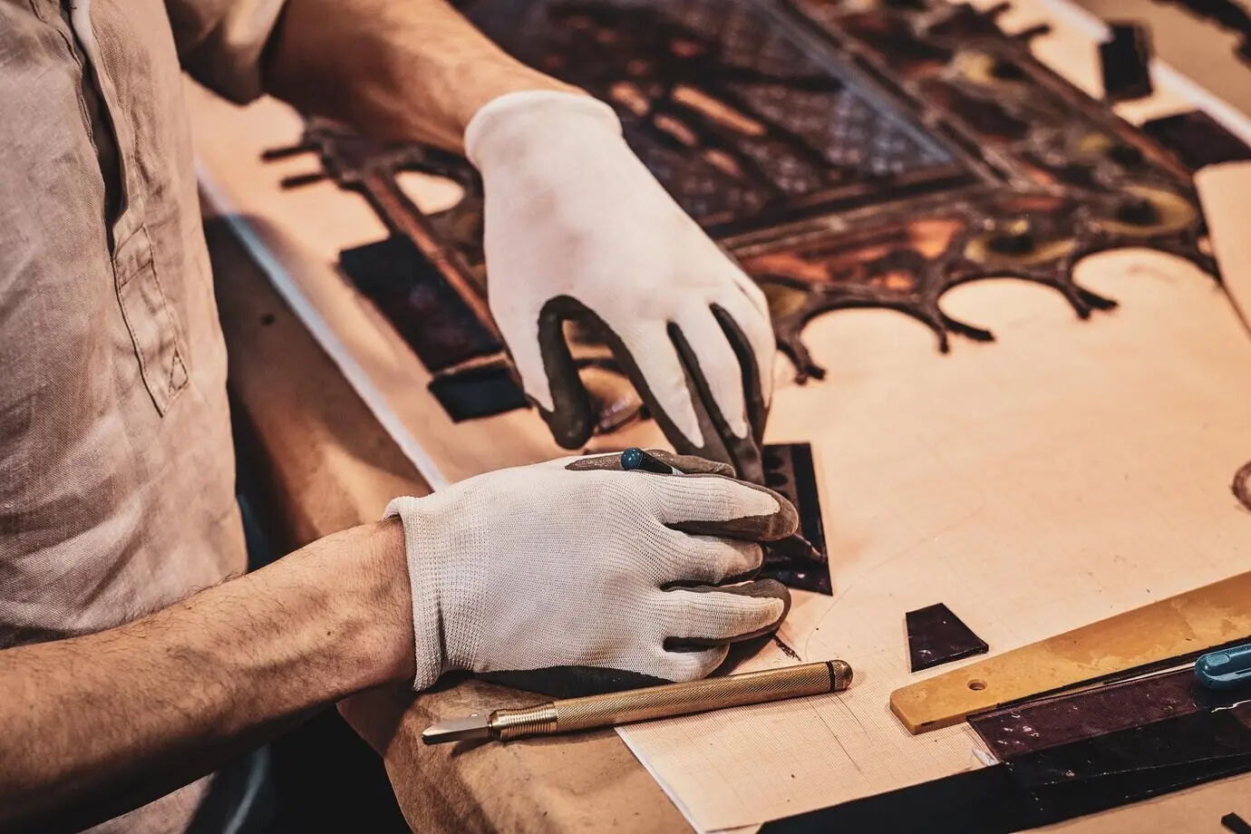 Ein Handwerker bringt ein weiteres Stück Buntglas am zerbrochenen antiken Fenster an.